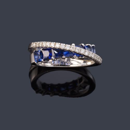  Anillo con banda de zafiros calibrados y de brillantes en montura de oro blanco de 18K.