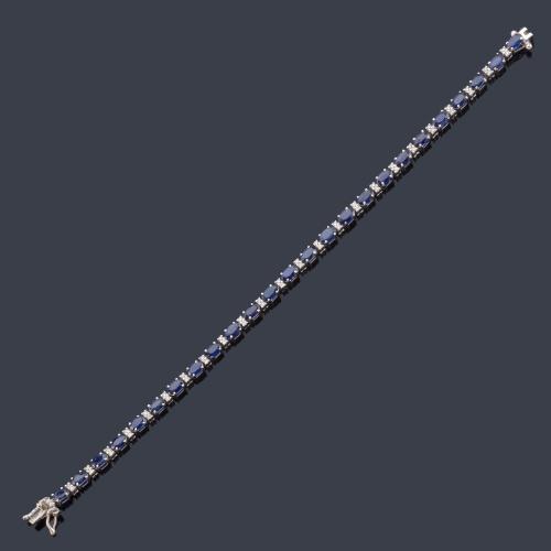 Pulsera rivière con zafiros talla oval intercalado con brillantitos en montura de oro blanco de 18K.