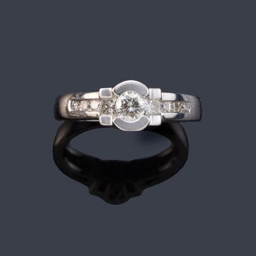  Anillo con brillante central de aprox. 0,24 ct y banda de diamantes talla princesa y brillantes en ambos lados de aprox. 0,23 ct en total.
