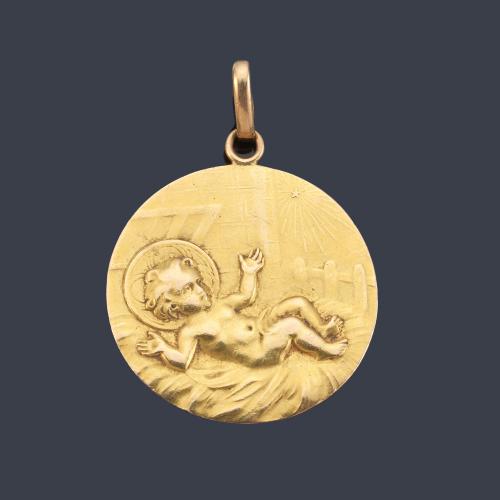 Medalla devocional con La Imagen del Niño Jesús en el pesebre realizada en oro amarillo de 18K.