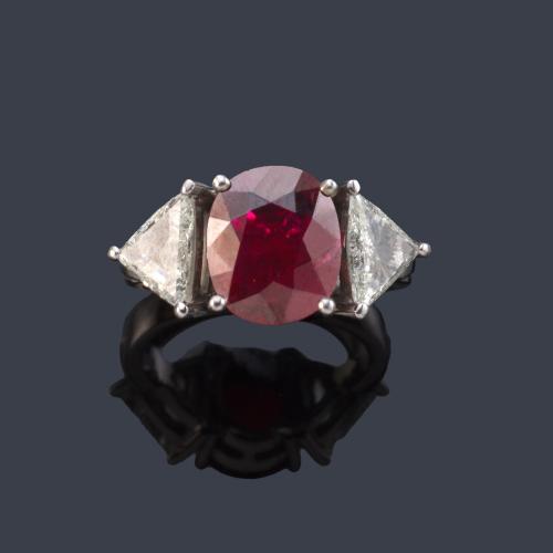 Anillo con rubí talla oval de aprox. 3,26 ct con dos diamantes talla triángulo de aprox. 0,40 ct cada uno. Certificado IGE.