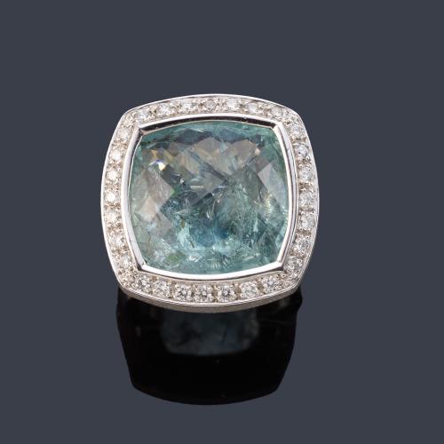 Anillo con aguamarina facetada con orla de brillantes en montura de oro blanco de 18K.