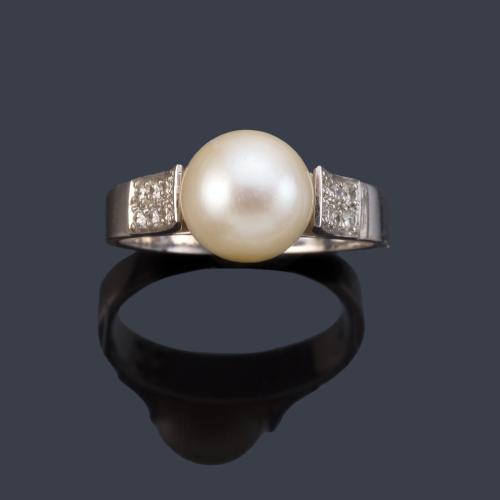 Anillo con perla de aprox. 9,11 mm con doble banda de brillantitos en ambos lados.