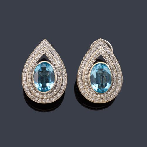 Pendientes cortos con diseño de perilla con pareja de topacios azules talla oval y doble orla de brillantes de aprox. 1,80 ct en total.