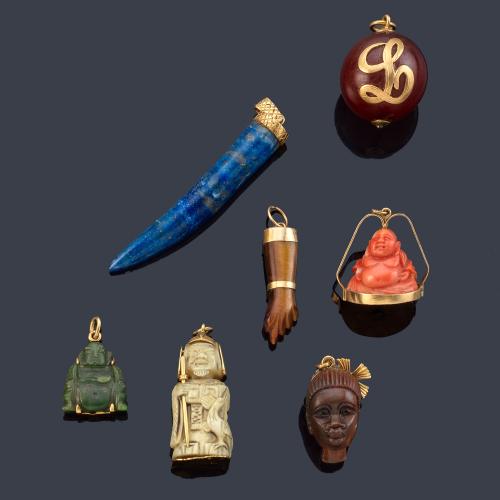 Siete colgantes con diferentes motivos, en piedras duras, coral y hueso.