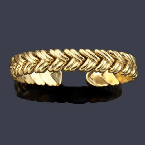 Pulsera semirrígida con diseño de entramado de espiga en oro amarillo de 18K.