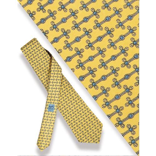 Corbata Hermés, doble nudo sobre fondo amarillo.