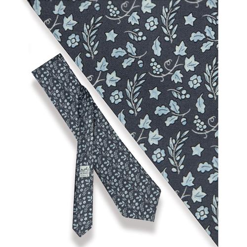 Corbata Hermés, racimos de uva y ramas de olivo sobre gris azulado.