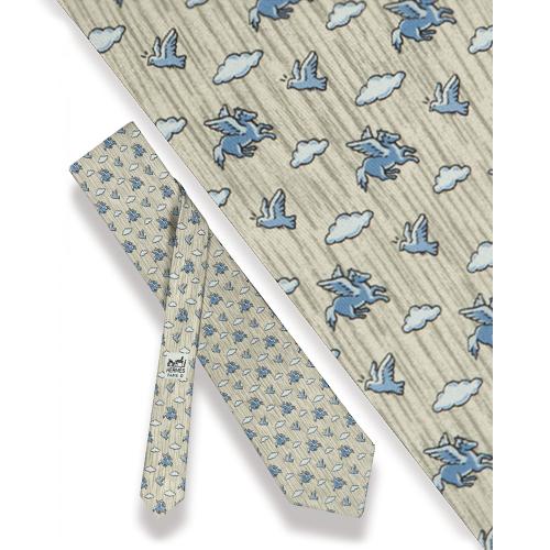 Corbata Hermés, caballo alado y pájaros sobre fondo gris.