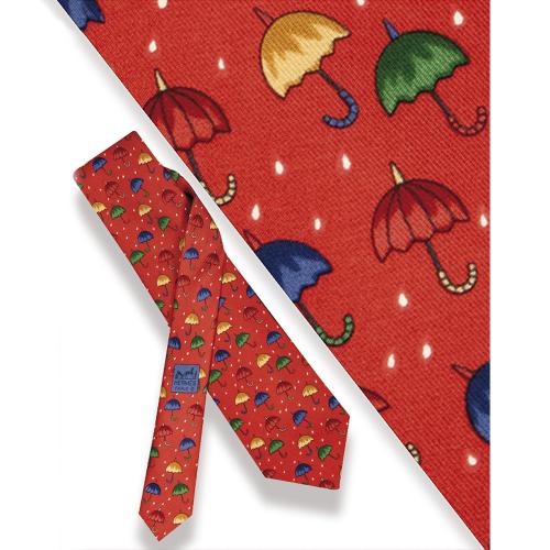 Corbata Hermés, paragüas y gotas de lluvia sobre fondo naranja.
