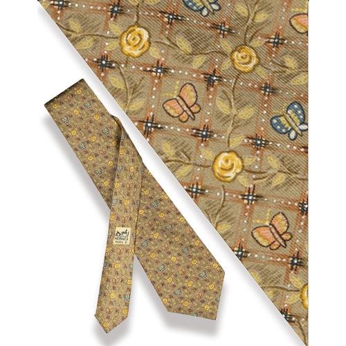 Corbata Hermès, motivo de mariposas y flores sobre fondo beige.