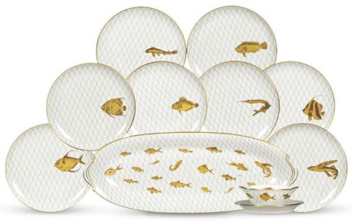 Vajilla en porcelana de L. Bernardaud & Cº de Limoges en blanco con diferentes peces, ninguno igual, dorados sobre fondo de redes en gris.