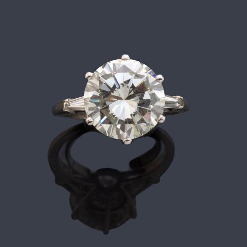 Solitario con brillante de aprox. 5,05 ct con un diamante talla trapecio a cada lado.