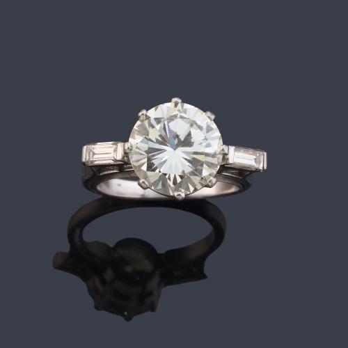 Solitario con brillante de aprox. 3,48 ct engastado en garra y dos diamantes talla baguette.