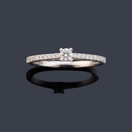 Anillo con brillante central de mayor tamaño y banda de brillantitos en ambos lados de aprox. 0,25 ct en total.