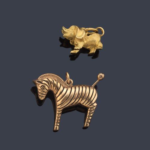 Dos colgantes con motivo de cebra y cerdito en oro amarillo de 18K.