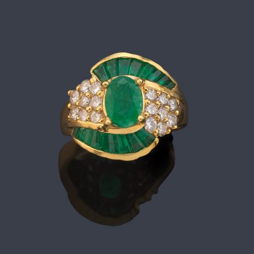 Anillo con esmeralda central talla oval de aprox. 1,00 ct sobre pavé de brillantes y motivos ondulados de esmeraldas calibrados.
