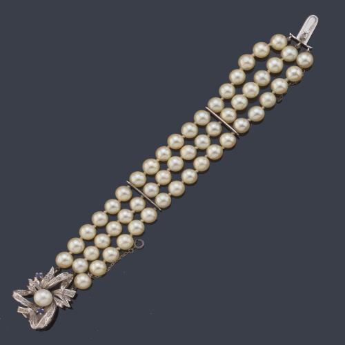 Pulsera con tres hilos de perlas de aprox. 6,61 - 6,77 mm con broche realizado en oro blanco de 18K, perlita central con diamantes talla sencilla.