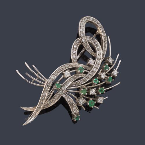 Broche con motivo de lazada con brillantes y esmeraldas en montura de oro blanco de 18K.