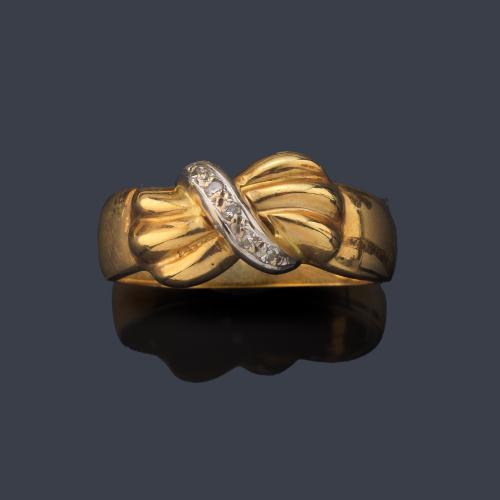 Anillo con frente en forma de lazada con banda central de diamantes en montura de oro amarillo de 18K.