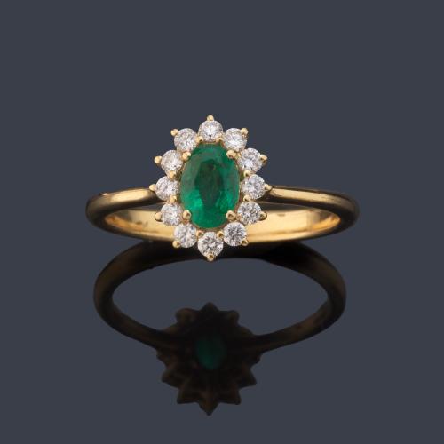 Anillo con esmeralda talla oval de aprox. 0,48 ct con orla de brillantitos de aprox. 0,26 ct en total.