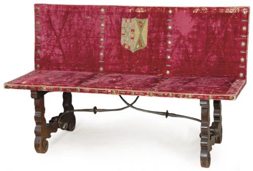Banco con patas recortadas en forma de lira en madera de nogal, unidas por fiadores abalaustrados en "S". Asiento y respaldo tapizado en terciopelo rojo y con tachuelas en latón. 