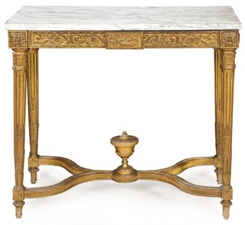 Consola Luis XVI en madera tallada y dorada, con patas acanaladas unidas por chambrana en X rematada en el centro por una copa clasica. Tapa de mármol blanco. Francia, principios S. XIX