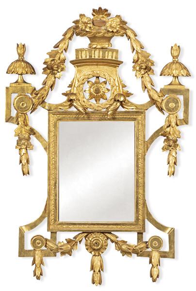Marco de espejo Carlos IV en madera tallada y dorada ornamentado con motivos florales y coronado por una cesta de flores y guirnaldas. España, finales del siglo XVIII.