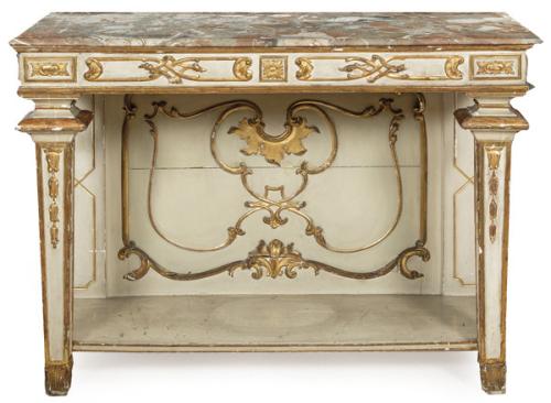 Consola Carlos IV en madera tallada, pintada y parcialmente dorada. Sobre patas en estípite. Ornamentada con motivos geométricos clasicistas. Cubierta superior en mármol de época posterior.