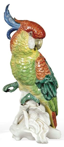 Figura de cacatua sobre tronco de árbol en porcelana pintada y esmaltada.