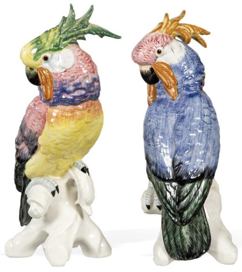 Pareja de figuras de cacatuas sobre ramas en loza pintada y esmalda.