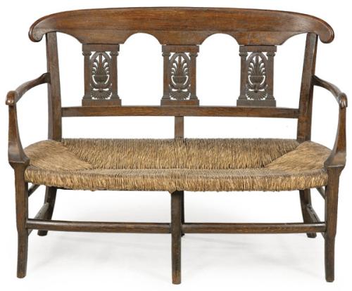 Canapé estilo Regencia en madera de roble tallada y moldada, con asiento de enea.