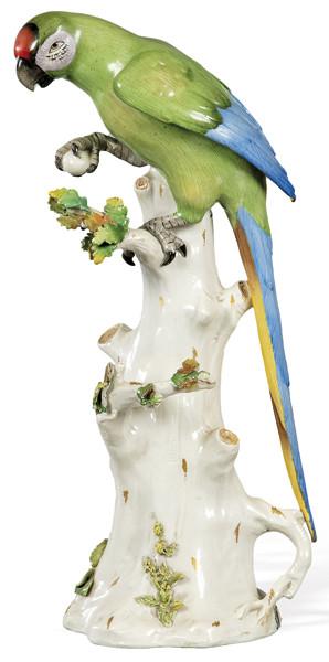 Figura de loro, sobre tronco de roble en porcelana pintada y esmaltada. Con marca en azul cobalto.