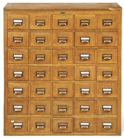 Archivador con treinta y cinco cajones en madera de roble con tiradores de metal.