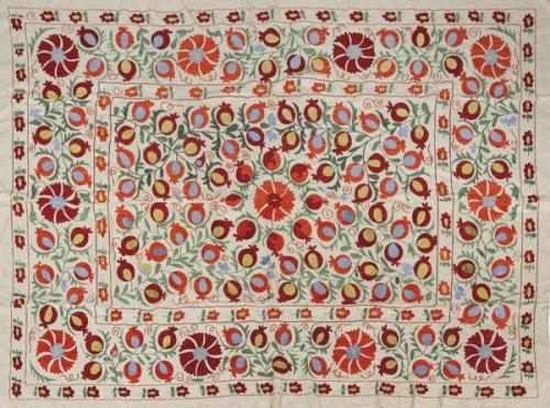 ouzani de algodón blanco con bordados de flores grandes y granadas en rojo, naranja, verde y azul, Uzbequistán S. XX.