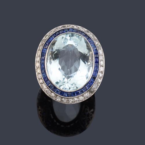 Anillo con aguamarina talla oval de aprox. 20,00 ct con orla de zafiros calibrados y diamantes talla 8/8 de aprox. 1,20 ct en total.