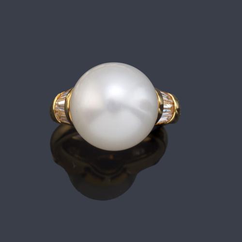 Anillo con perla Australiana de aprox. 13,62 mm y diamantes talla baguette de aprox. 0,76 ct en ambos lados.
