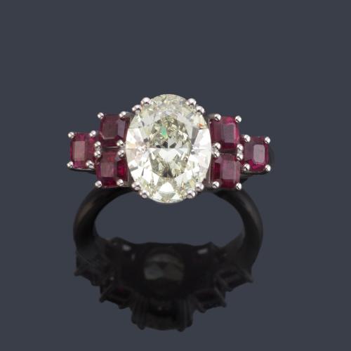  Anillo con diamante talla oval de aprox. 2,62 ct con tres rubíes calibrados en ambos lados de aprox. 1,00 ct en total. Certificado IGI.