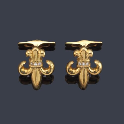 Gemelos con diseño de flor de lis con banda de brillantes en montura de oro amarillo de 18K.