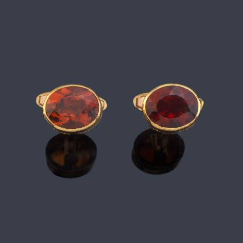 Gemelos con diseño oval y pareja de topacios naranjas facetados en montura de oro amarillo de 18K.