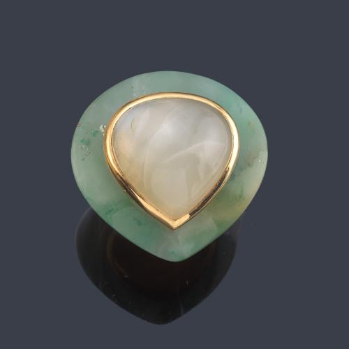 Anillo maxi con piedra luna central en montura de tallada en jade y motivo en oro amarillo de 18K.
