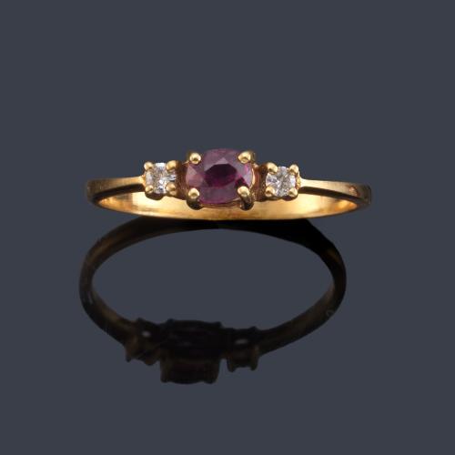 Anillo con rubí talla oval y dos brillantitos en montura de oro amarillo de 18K.