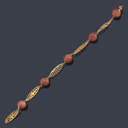  Pulsera con cinco cuentas esféricas de cuarzo piedra sol con eslabones calados en oro amarillo de 18K.