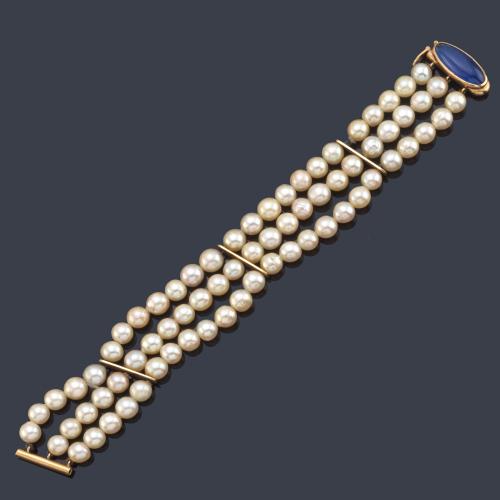 Pulsera con tres hilos de perlas con pasadores en oro amarillo de 18K y cierre con vidrio azul.