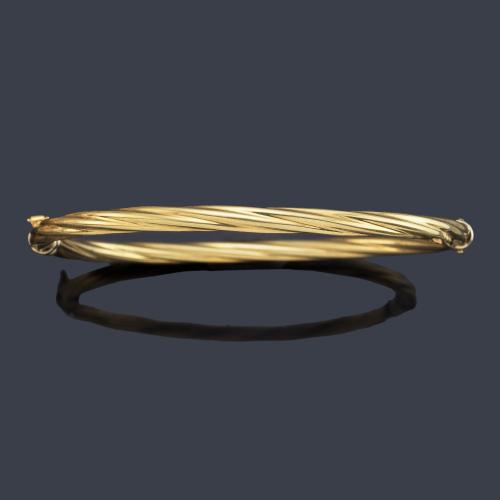 Pulsera rígida con diseño entorchado en montura de oro amarillo de 18K.