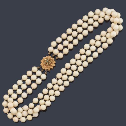 Collar con tres hilos de coral de aprox. 9,03 - 9,06 mm con cierre floral en oro amarillo de 18K, esmeraldas y esmalte verde.