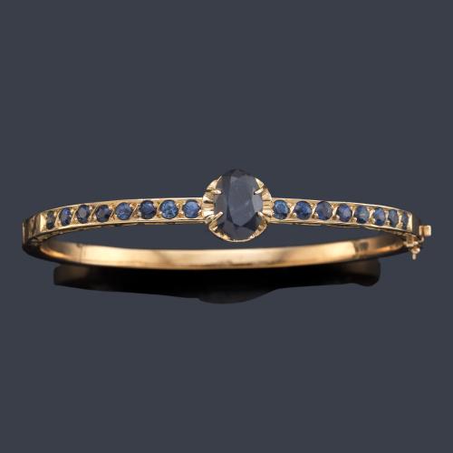 Pulsera rígida con zafiro talla oval de aprox. 2,00 ct en montura de oro amarillo de 18K.