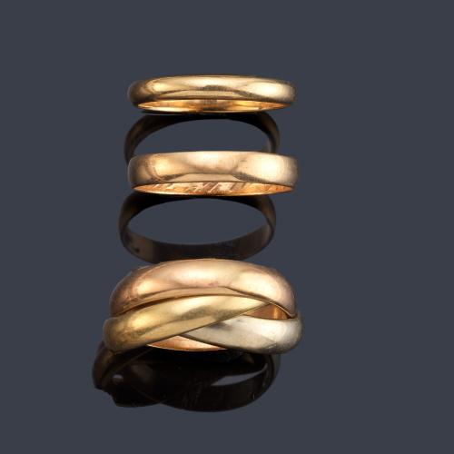 Lote con dos alianzas (con inscripciones) y anillo con tres aros en oro blanco, rosa y amarillo de 18K.