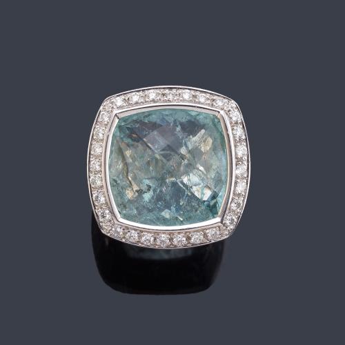 Anillo con aguamarina facetada con orla de brillantes en montura de oro blanco de 18K.