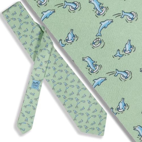 Corbata Hermés con motivos de delfines sobre fondo verde